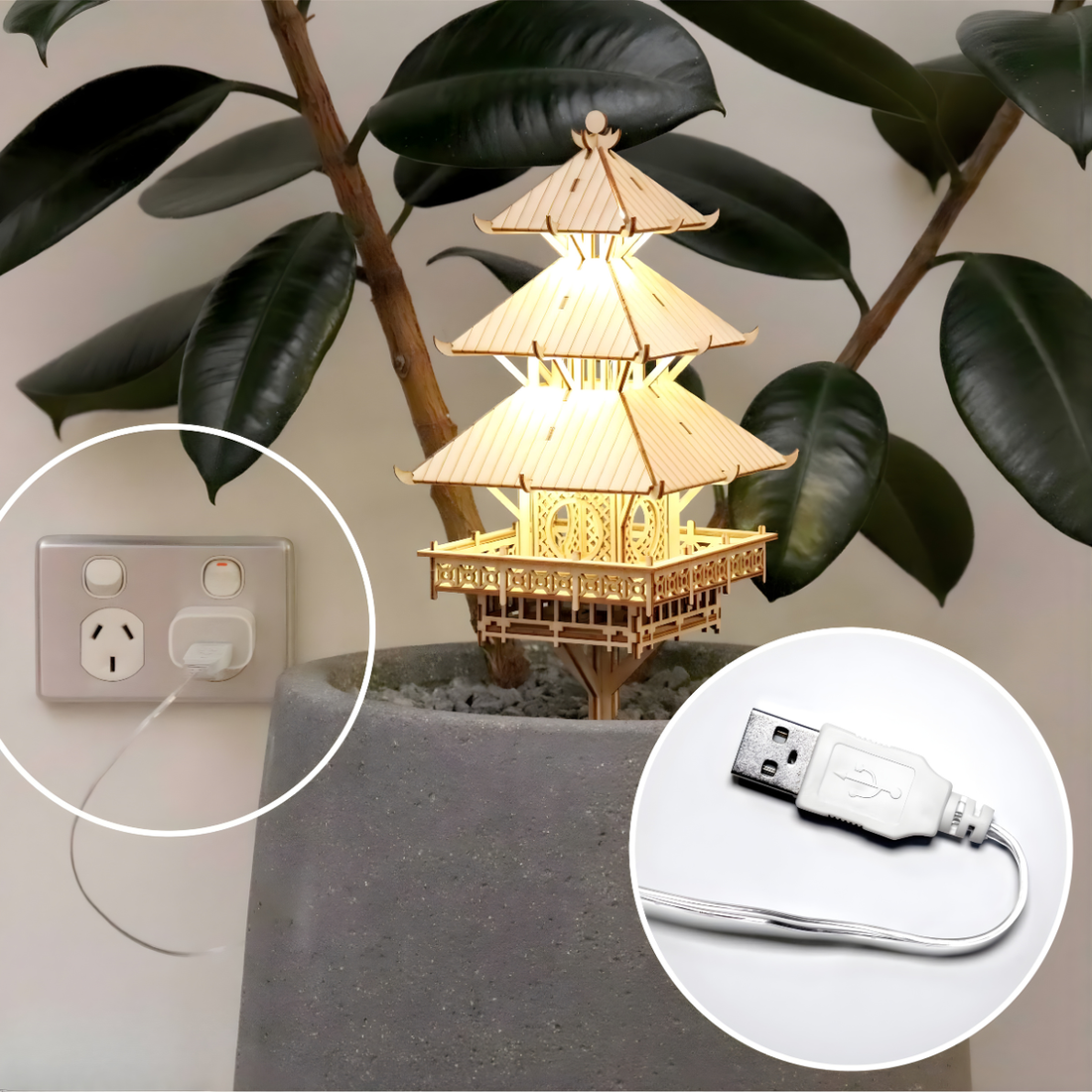 Decorative tiny treehouse pagoda  with USB plug powered fairy lights placed in a rubber tree plant with leaves in the background.